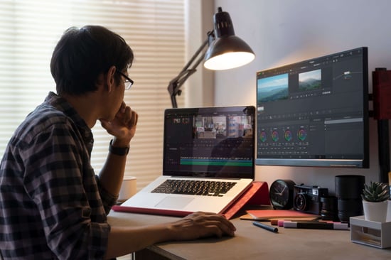Male freelancer editing video on computer